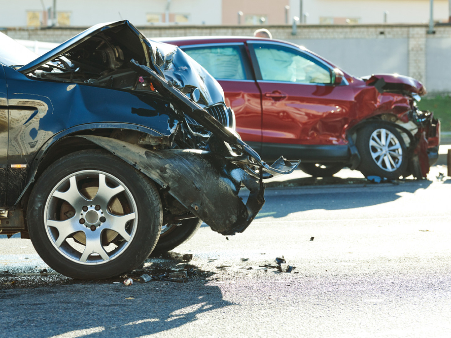 Motor vehicle accident between blue car and red car in the road